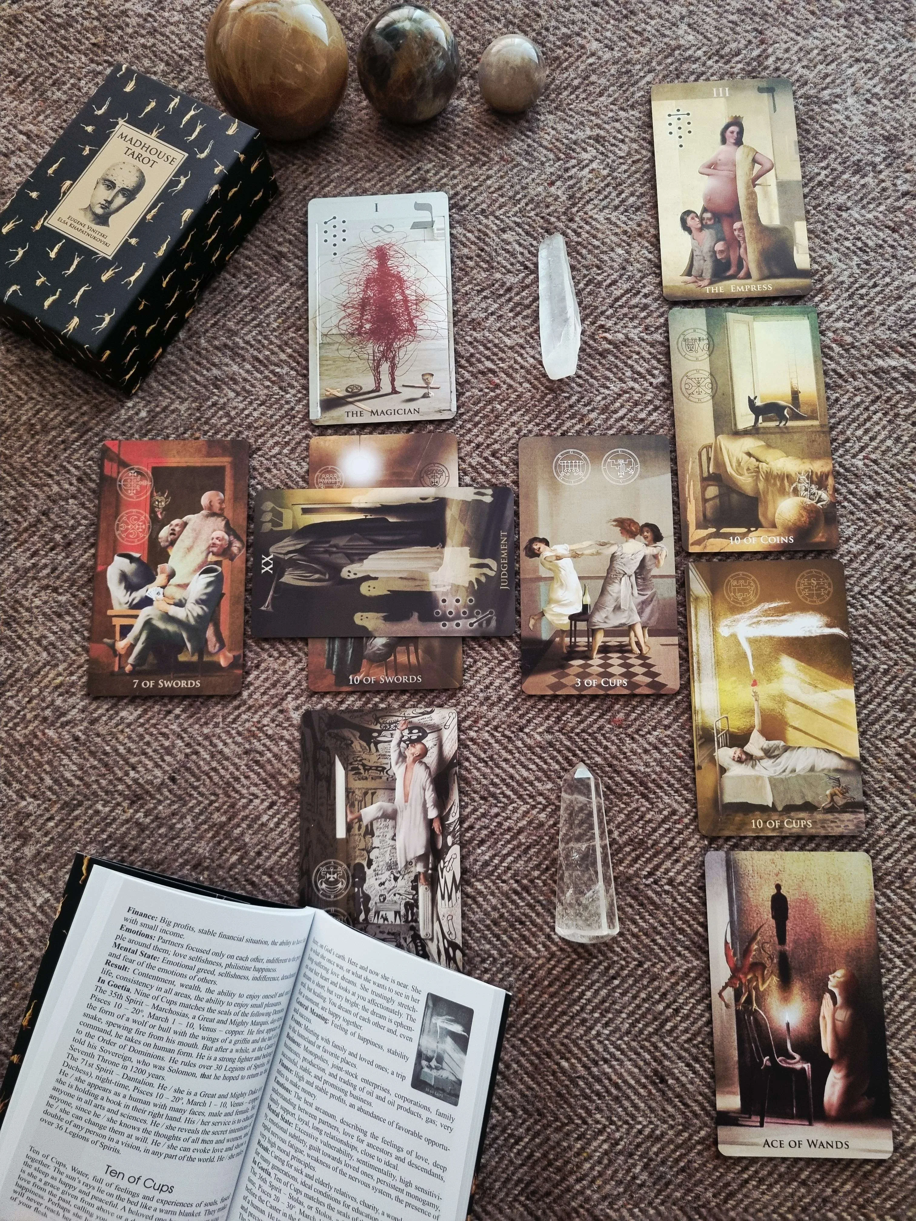 a large spread of tarot cards including The Magician, The Empress and Judgement