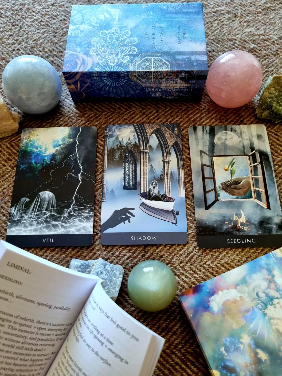 Veil, Shadow and Seedling cards from the Deep Place Oracle with an open guidebook page
