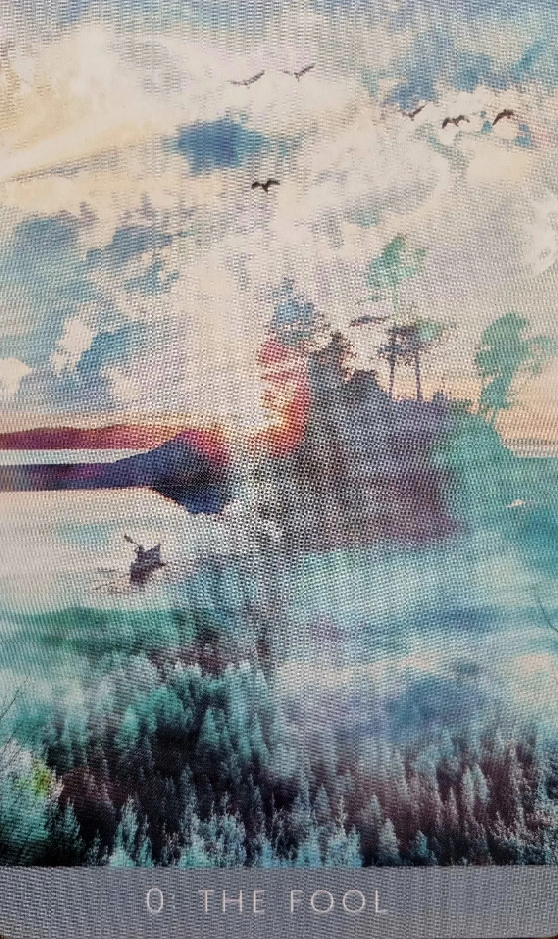 The Fool card from the Rooted Remembrance Tarot, a misty lakeside scene at dawn with birds in flight, a distant moon and a lone boat crossing the water
