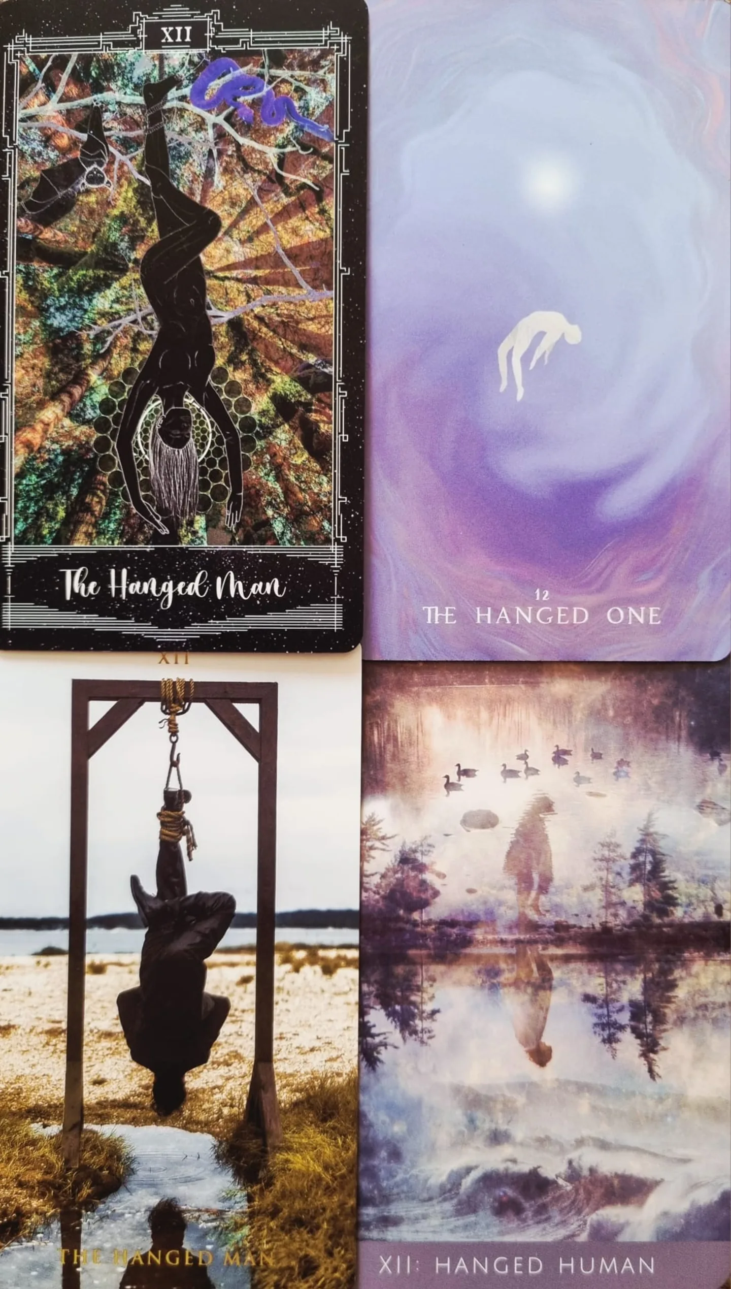 The Hanged Man tarot card compared across the Cosmosis Tarot, The Shadows We Cast Tarot, Rooted Remembrance Tarot and The Somnia Tarot