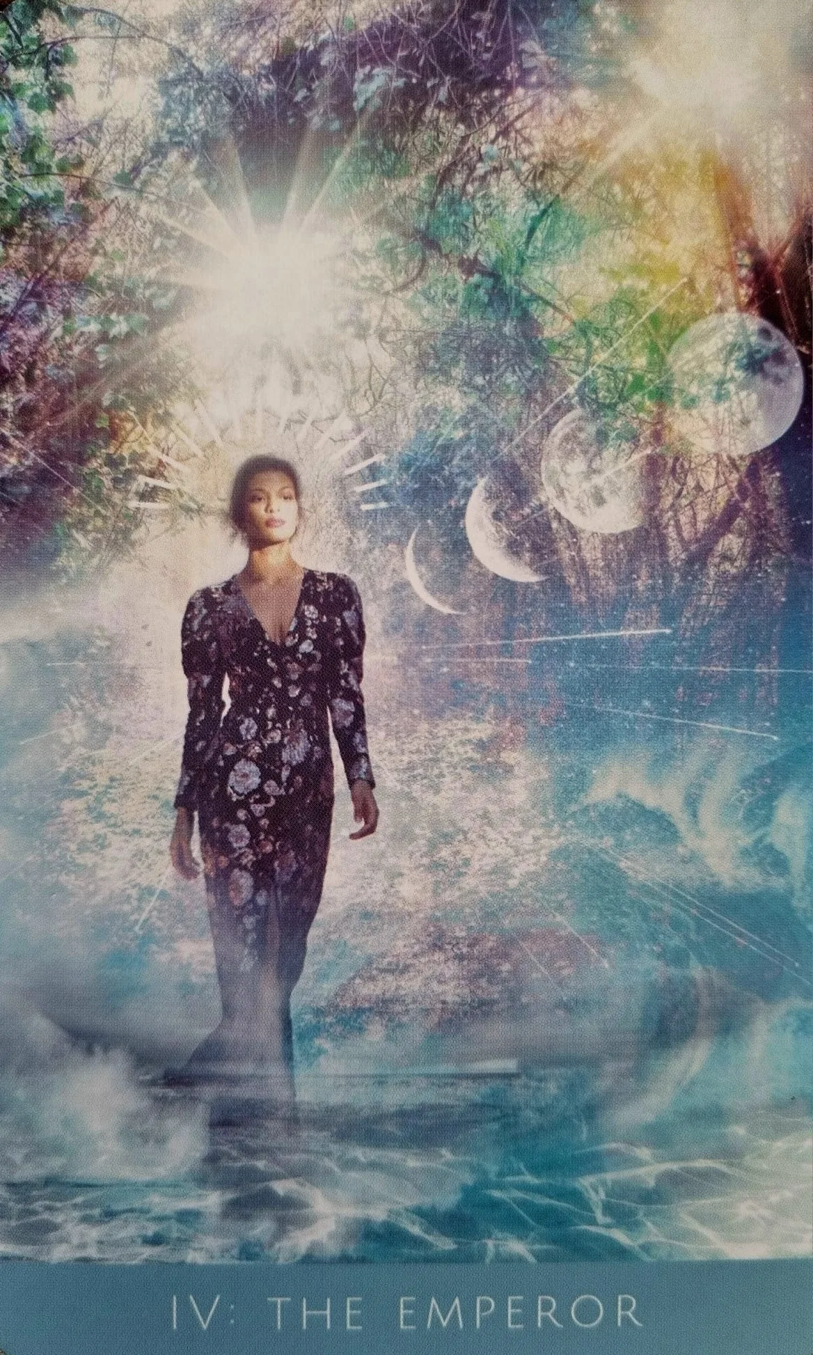 The Emperor card from the Rooted Remembrance Tarot, a figure walking across water beneath a radiant light and three moons