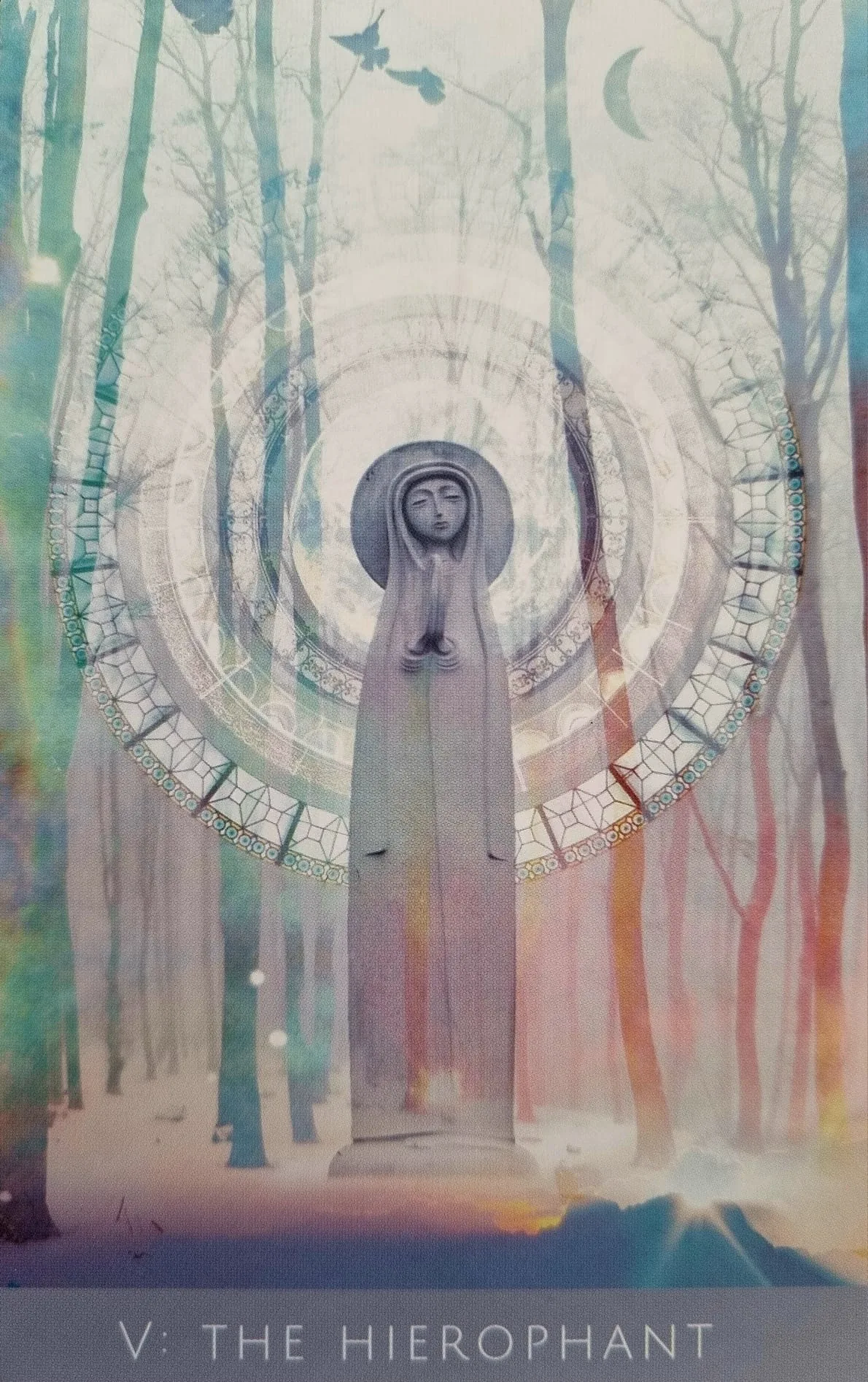 The Hierophant card from the Rooted Remembrance Tarot, a robed, hooded figure standing at the centre of concentric stained-glass rings in a winter forest