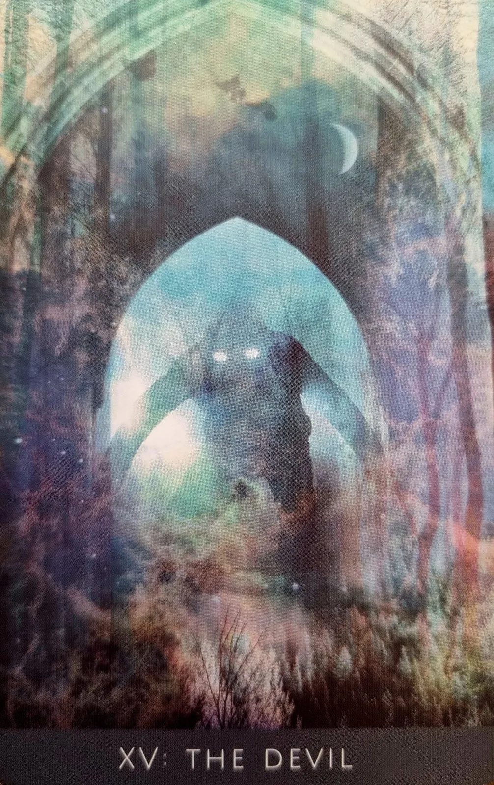 The Devil from the Rooted Remembrance Tarot, a hooded figure with glowing eyes beneath a gothic arch in a misty wood