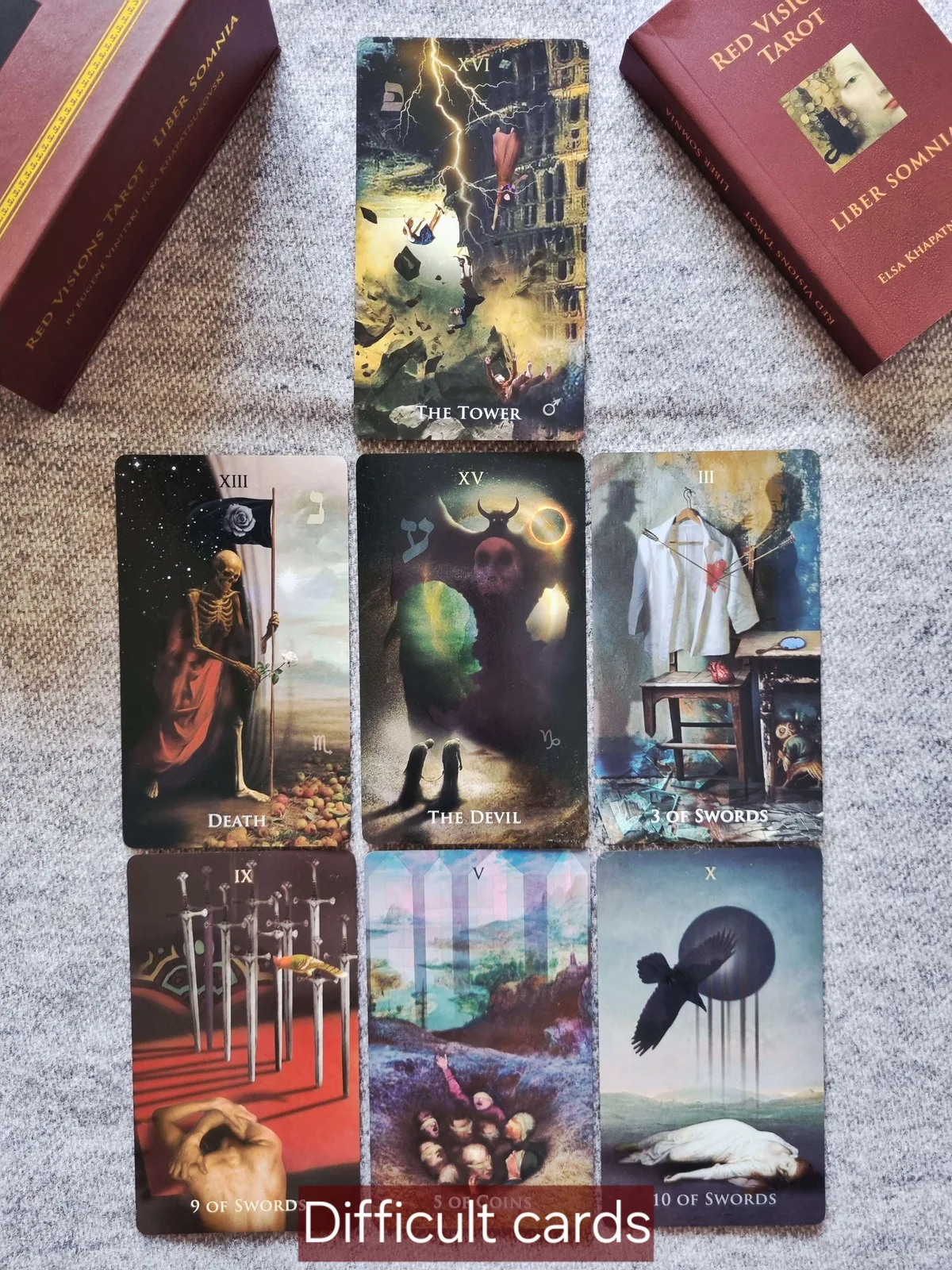 Difficult tarot cards The Tower, Death, The Devil and Nine and Ten of Swords laid out beside the Liber Somnia box