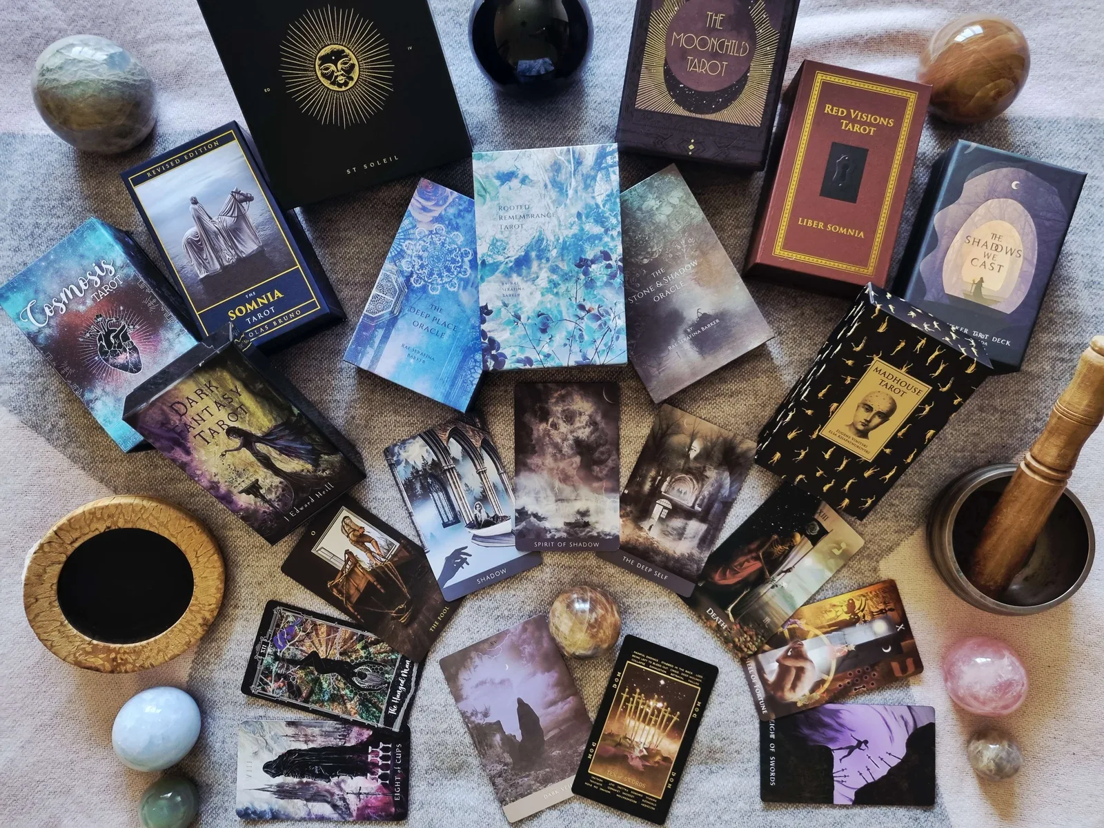 Collection of shadow work tarot decks arranged around a bowl and crystals