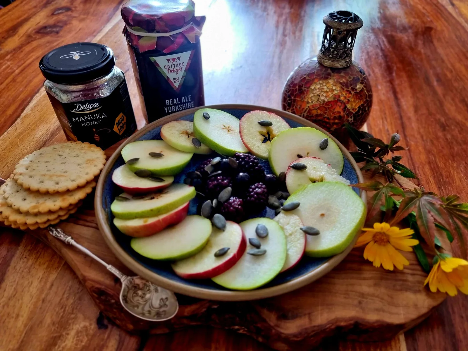 a plate of seasonal fruit, nuts and honey for a Mabon harvest table