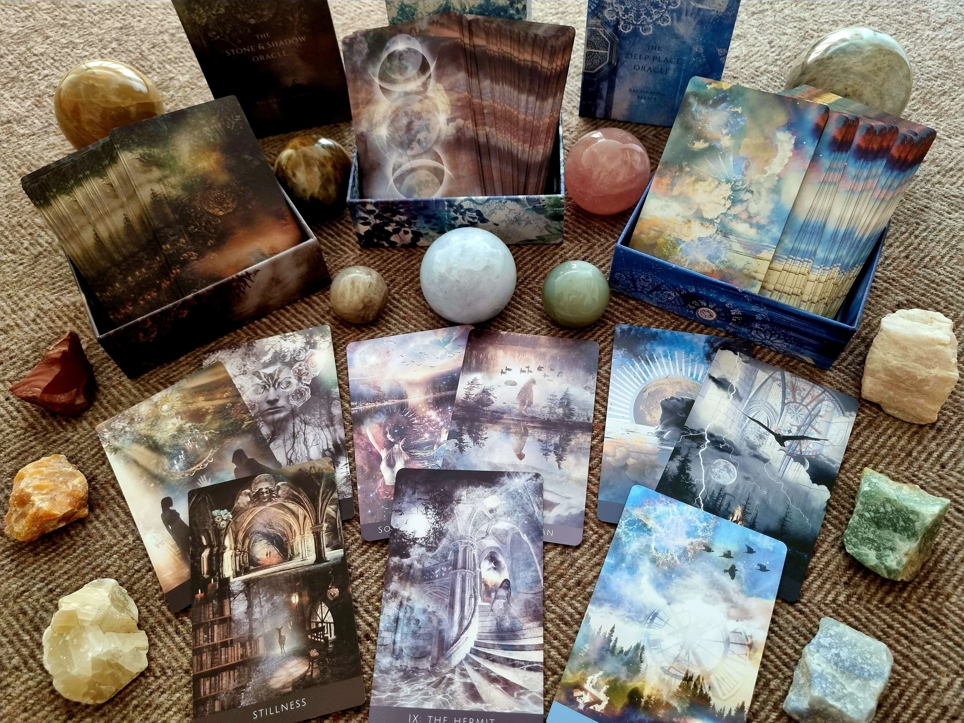 three of Rae Serafina Barker's decks with crystal spheres and stones
