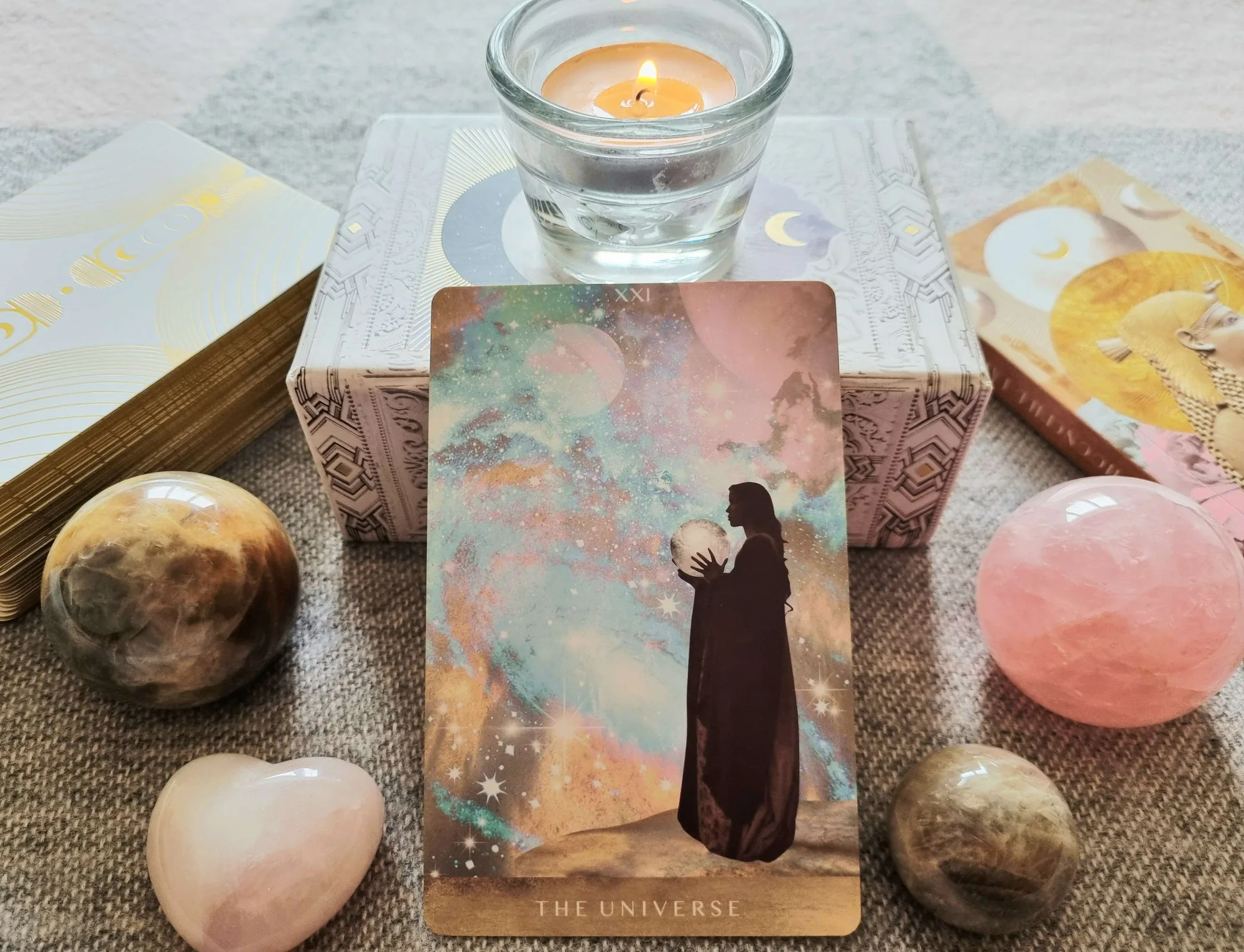 Tarot meditation with The Universe card from the Moonchild Tarot beside a lit candle and rose quartz