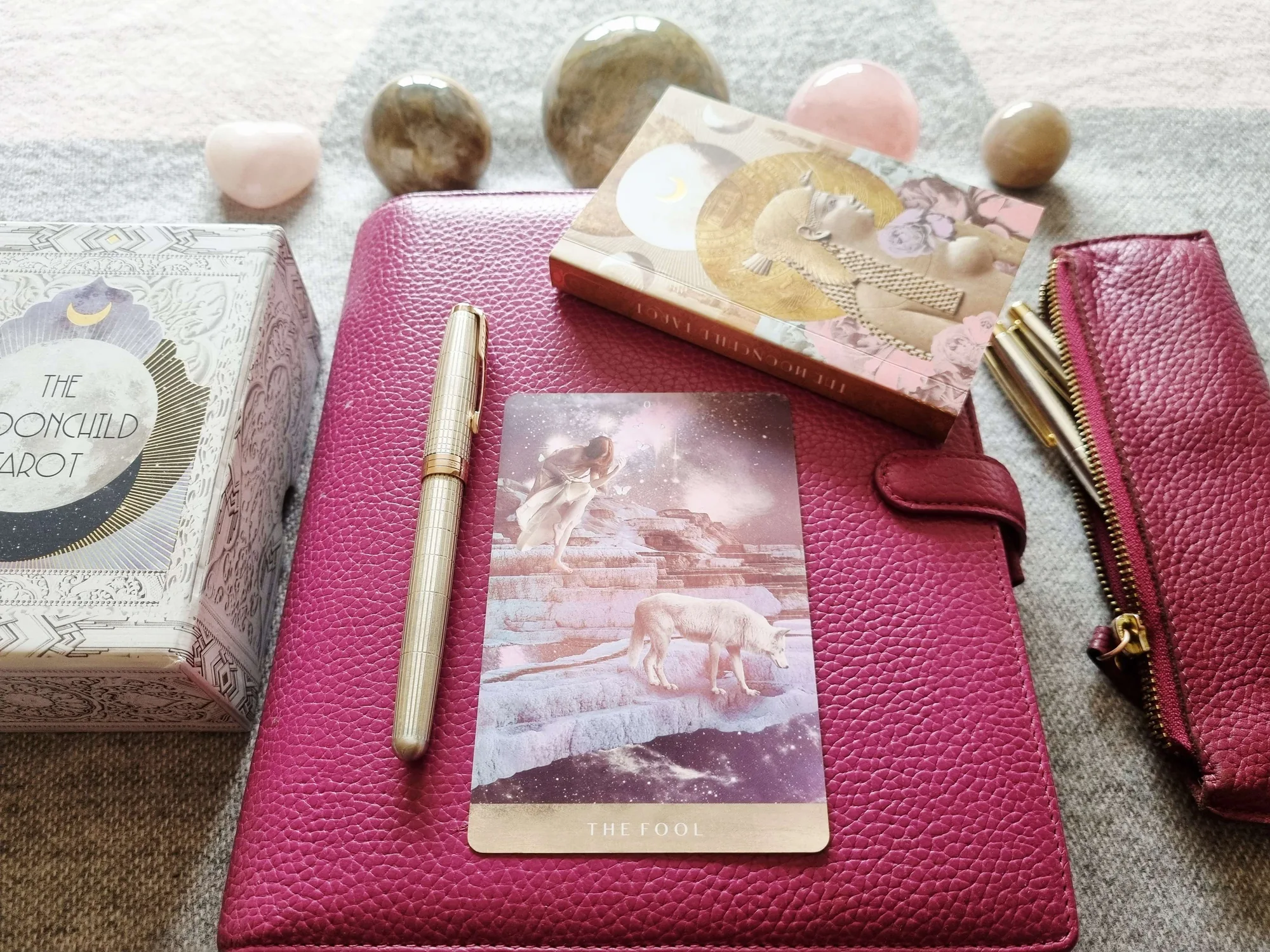 The Fool from the Moonchild Tarot on a pink journal with a gold fountain pen