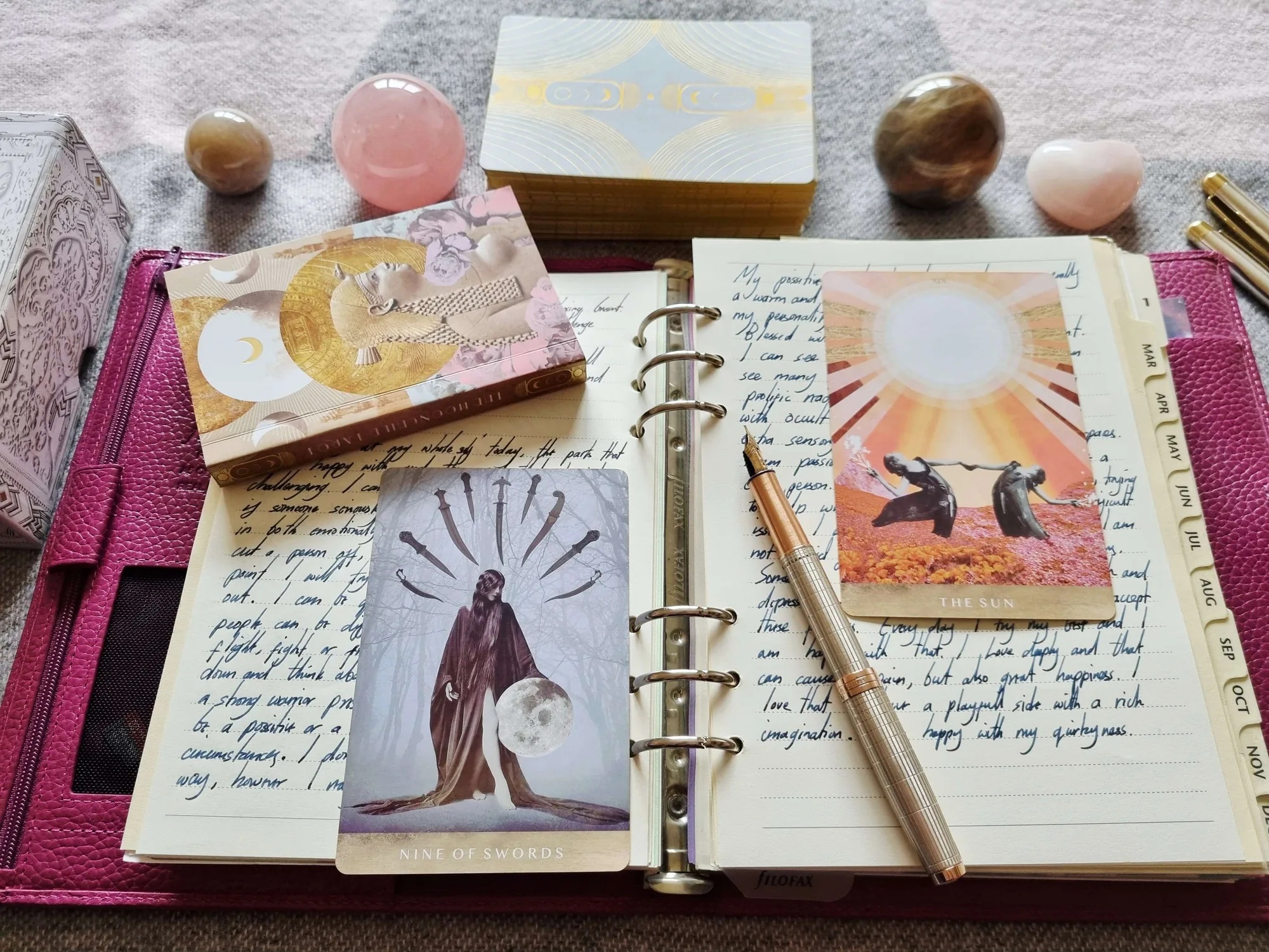 Tarot journaling with the Nine of Swords and The Sun from the Moonchild Tarot beside an open journal