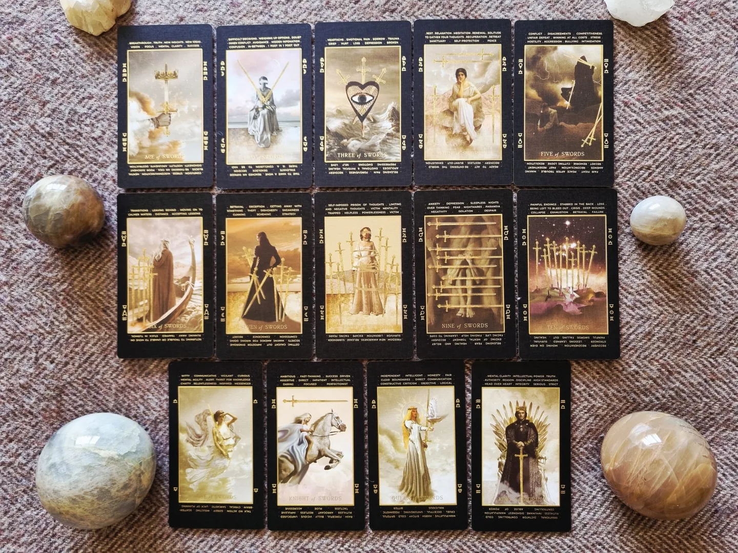 The complete suit of Swords from the Lucid Dreams Tarot, fourteen cards laid out in rows with crystal spheres