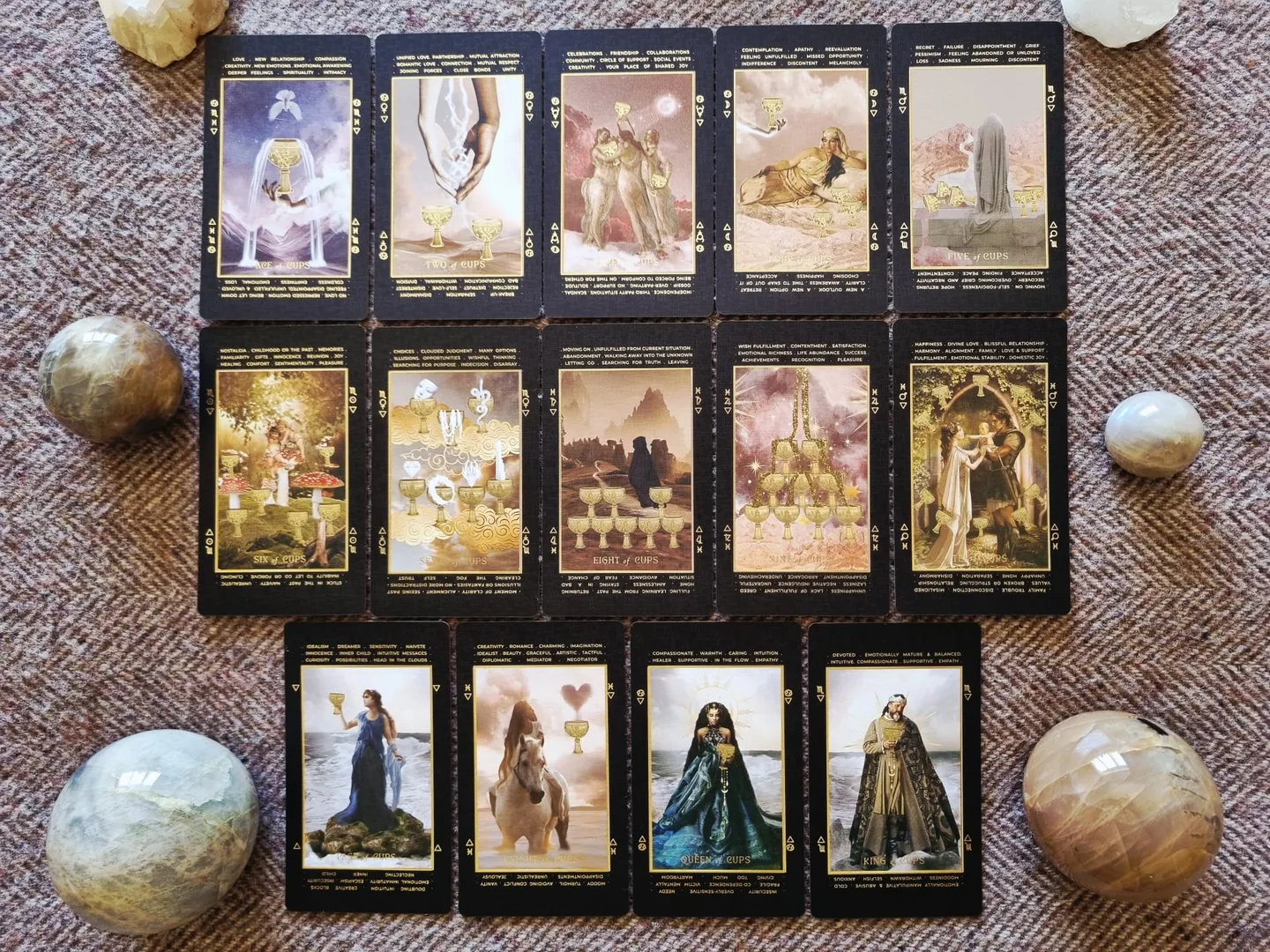 The complete suit of Cups from the Lucid Dreams Tarot, fourteen cards laid out in rows with crystal spheres