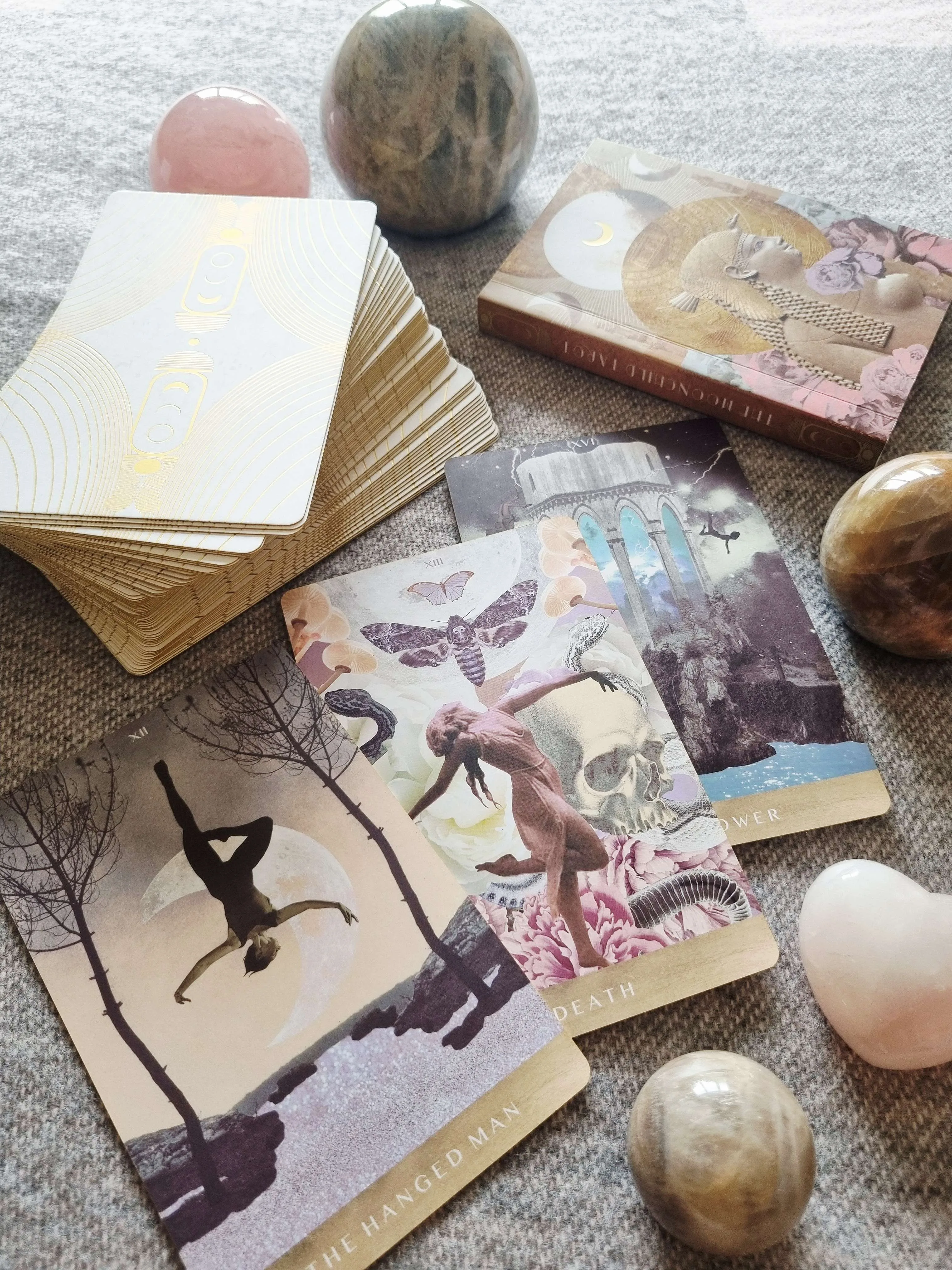 The Moonchild Tarot White and Gold Edition box beside The Hanged Man, Death and The Tower cards
