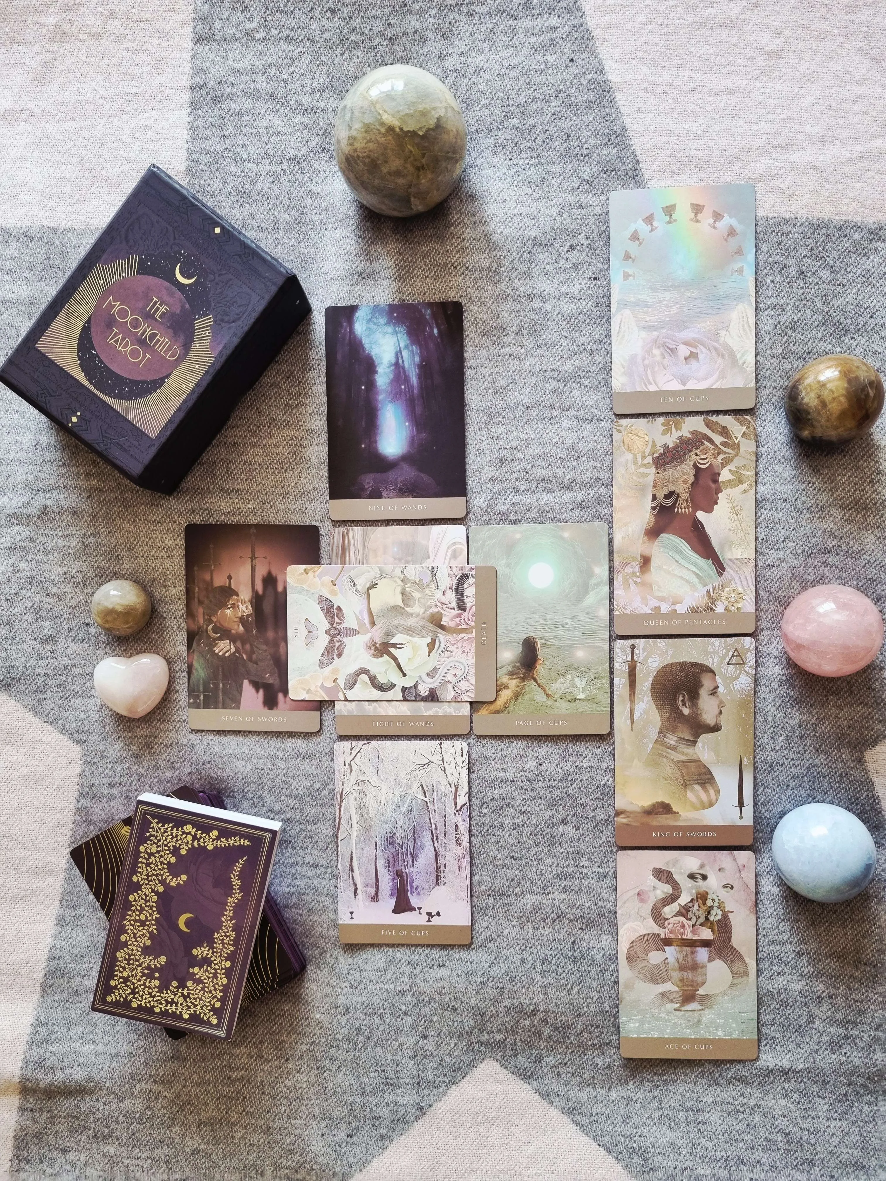 a cross-shaped spread of Moonchild Tarot Shadow Work Edition cards including Death, Ten of Cups and Seven of Swords