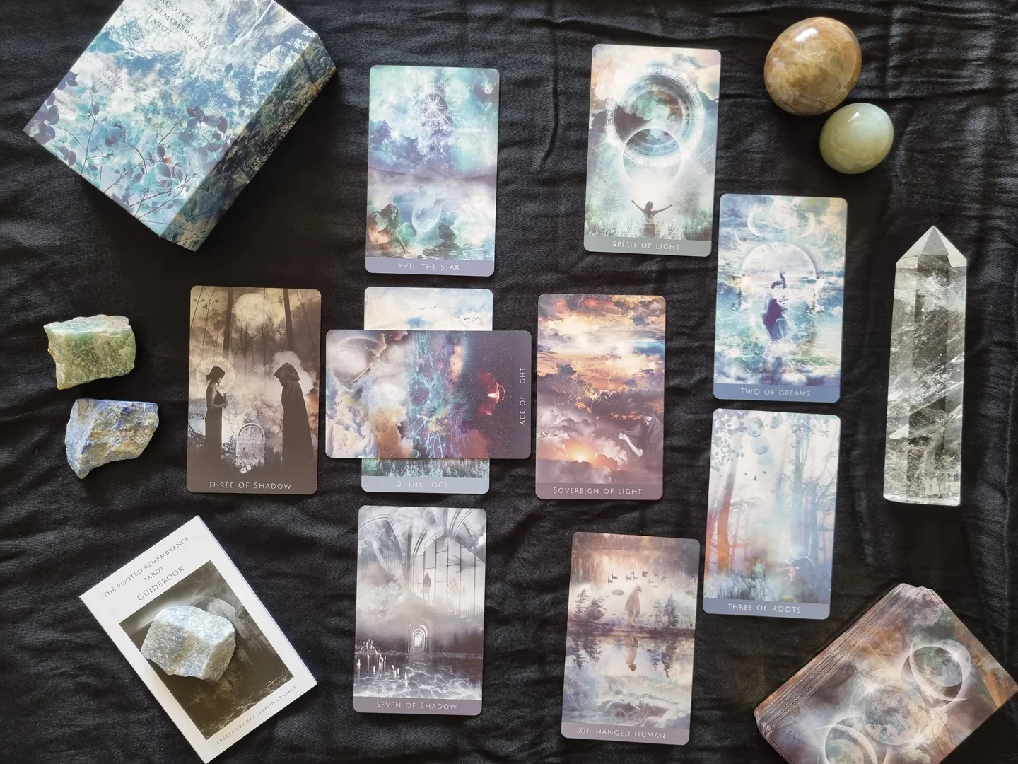 Rooted Remembrance Tarot cards laid flat with the presentation box, crystals and a guidebook card