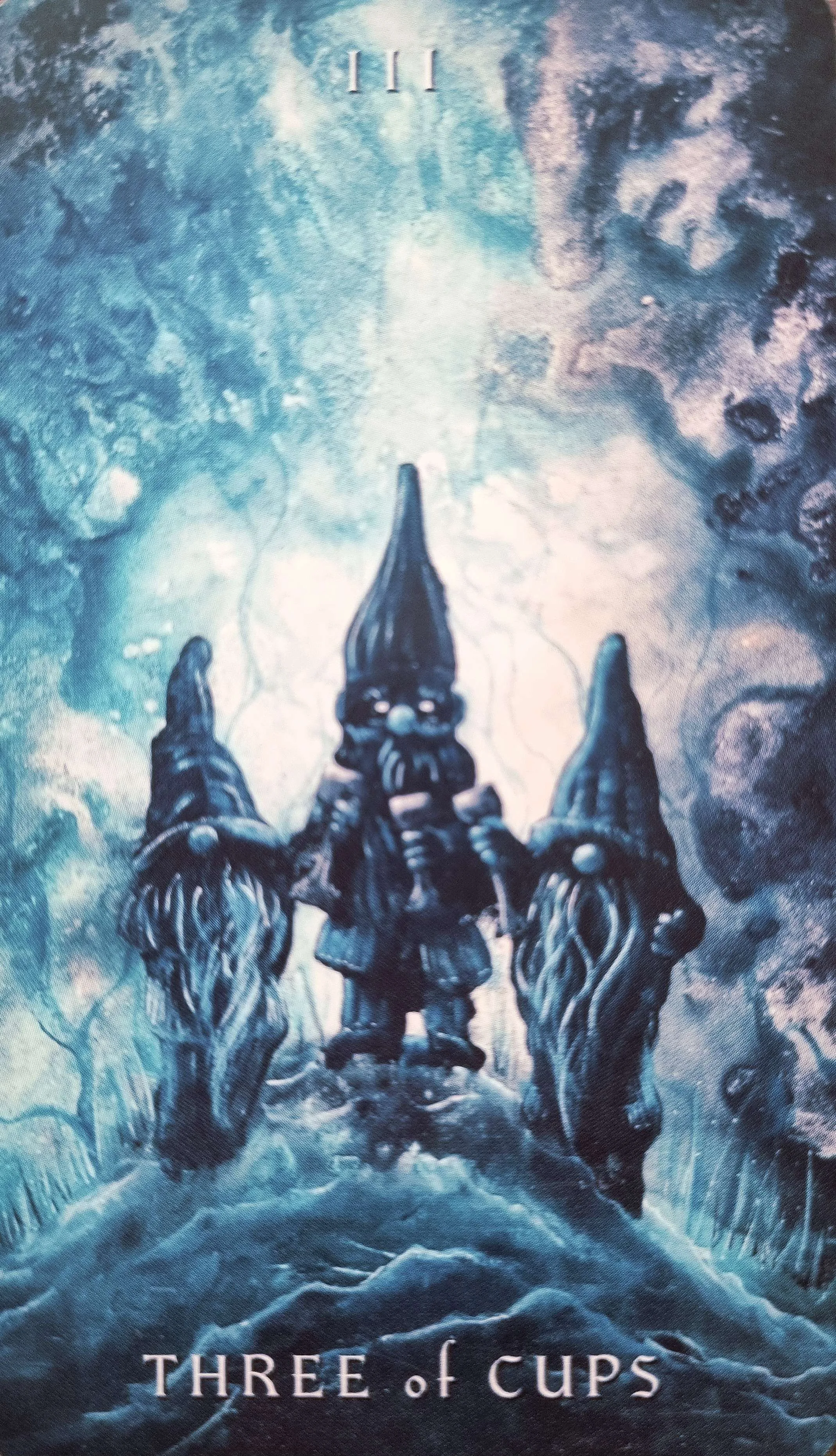 Three of Cups tarot card, three hooded figures walking together through a misty forest