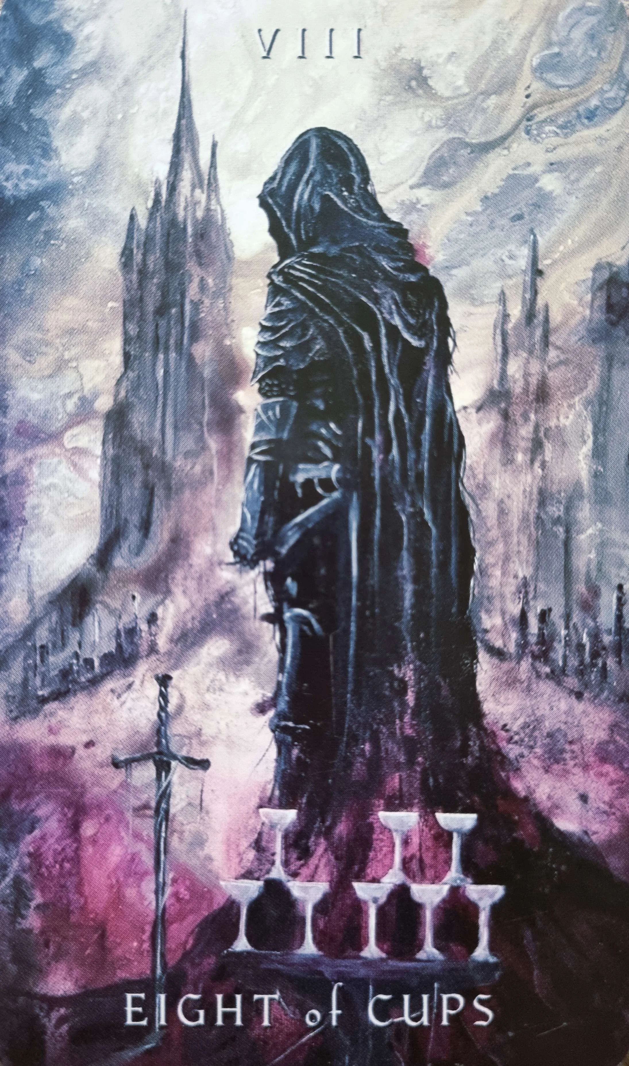 Eight of Cups tarot card, a cloaked figure walking away from eight stacked cups towards distant spires