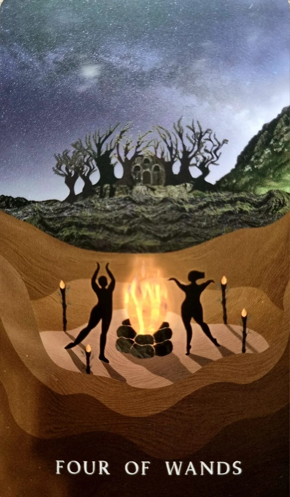 Four of Wands tarot card, figures dancing around a bonfire beneath twisted trees