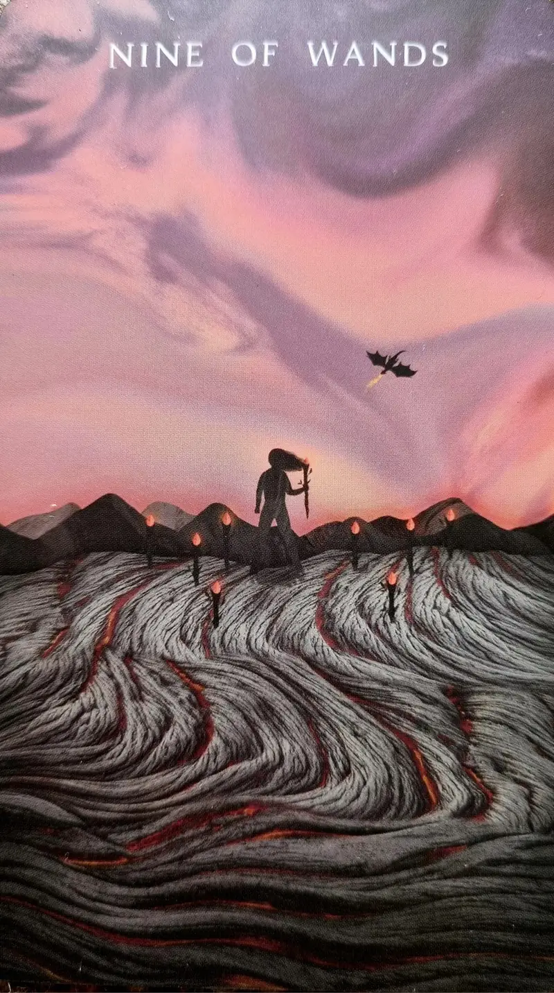 Nine of Wands tarot card, a lone figure with a torch on a ridge of cooling lava beneath a pink sky