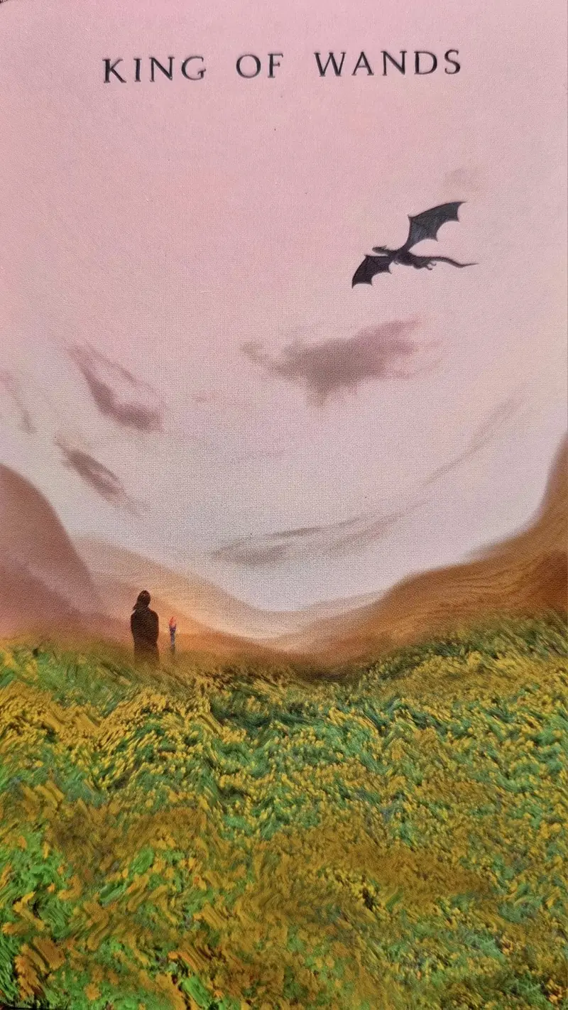 King of Wands tarot card, two figures with a torch on a green hillside beneath a distant dragon