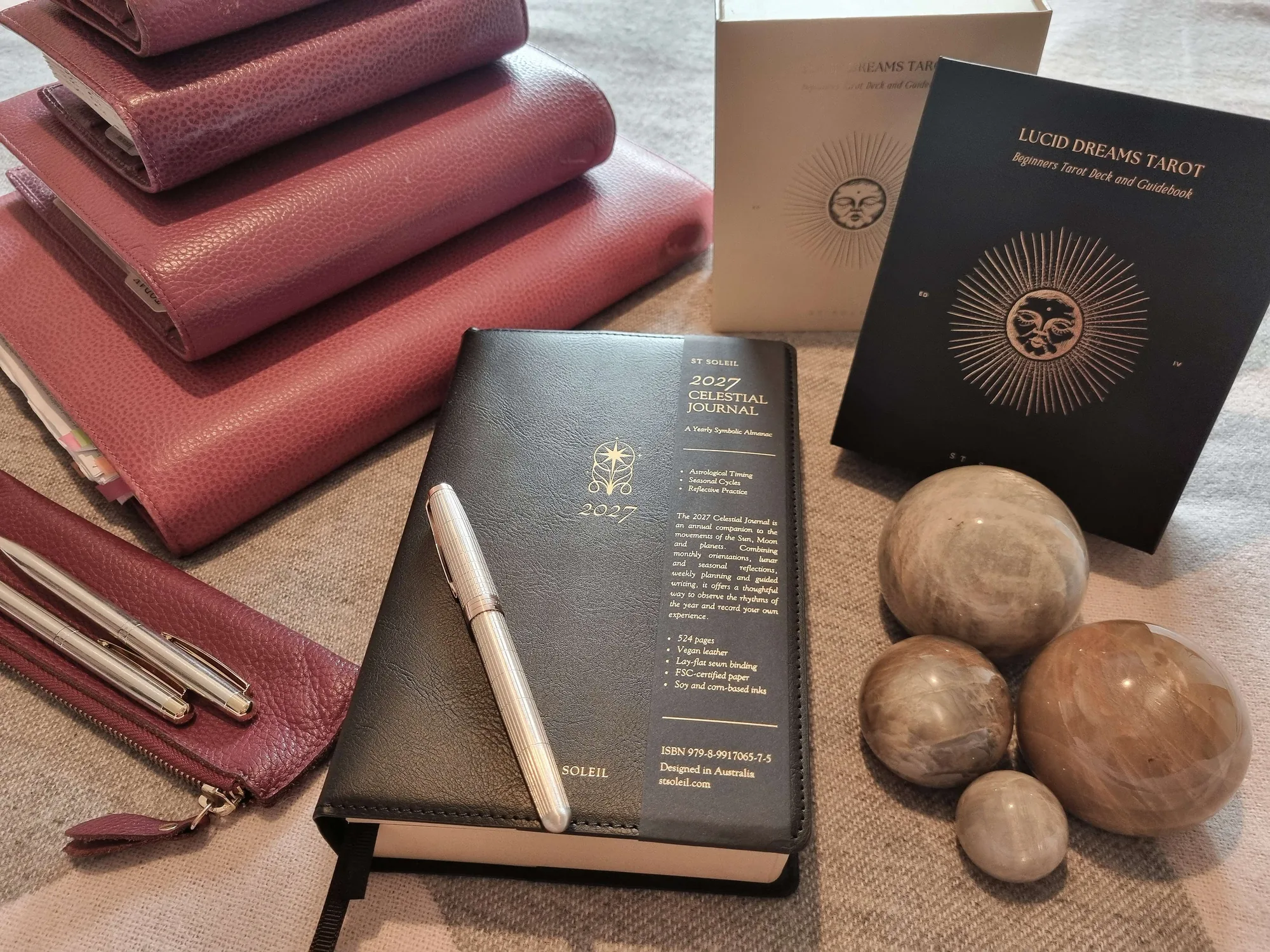 Four pink leather Filofaxes beside the St Soleil 2027 Celestial Journal and Lucid Dreams Tarot decks