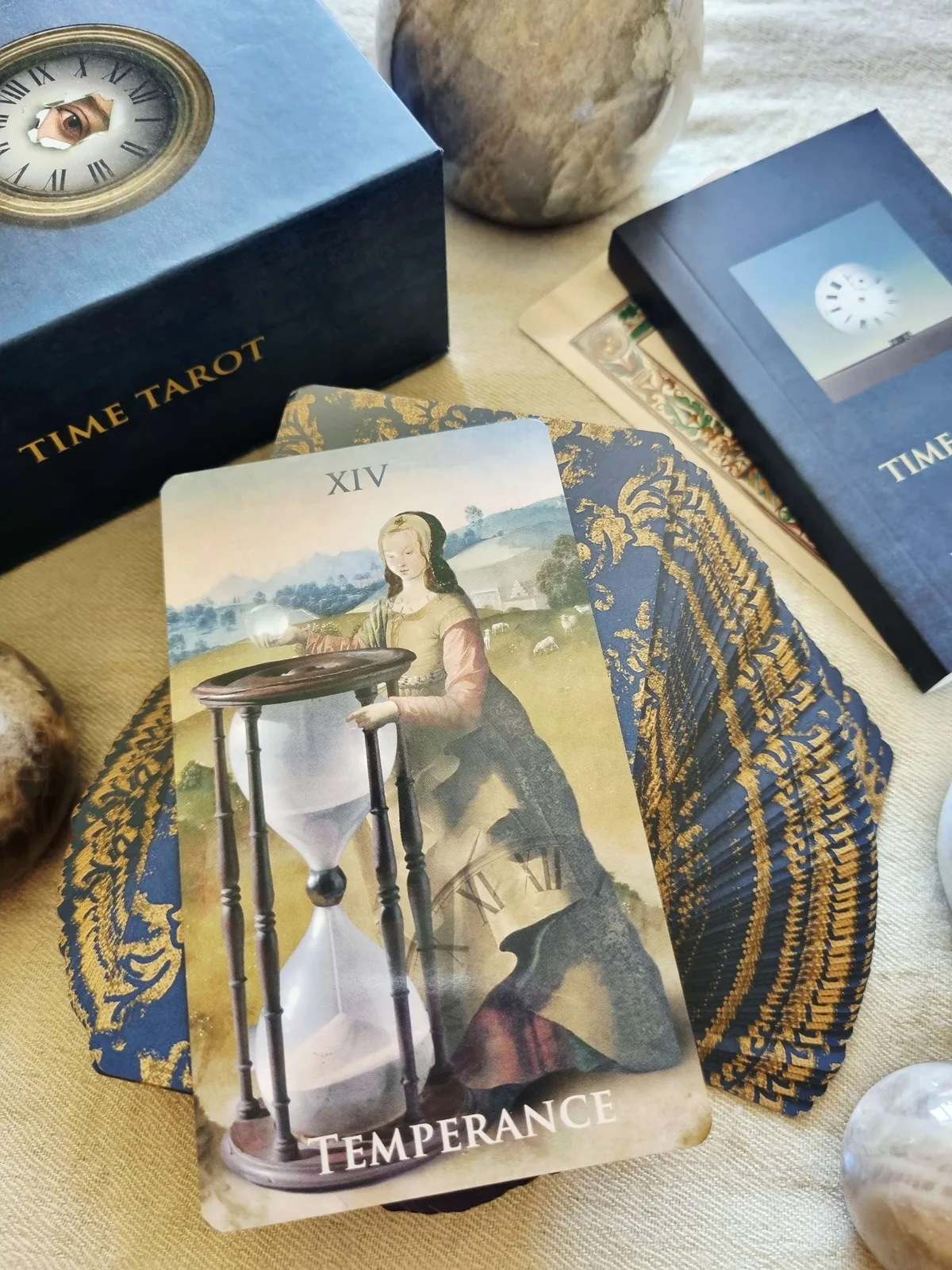 Time Tarot Temperance card with a large hourglass, beside the box and gold gilded deck
